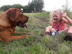 Hond Jo en dochtertje Iris zitten samen op het gras