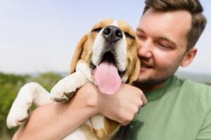 Een man die zijn blije beagle vasthoudt