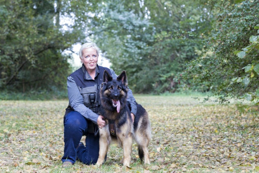 Janie zit gehurkt met haar hond Teun op een grasveld